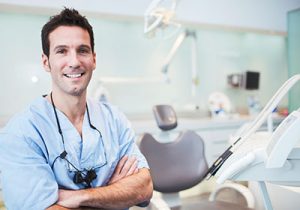 smiling male dentist in his dental exam room